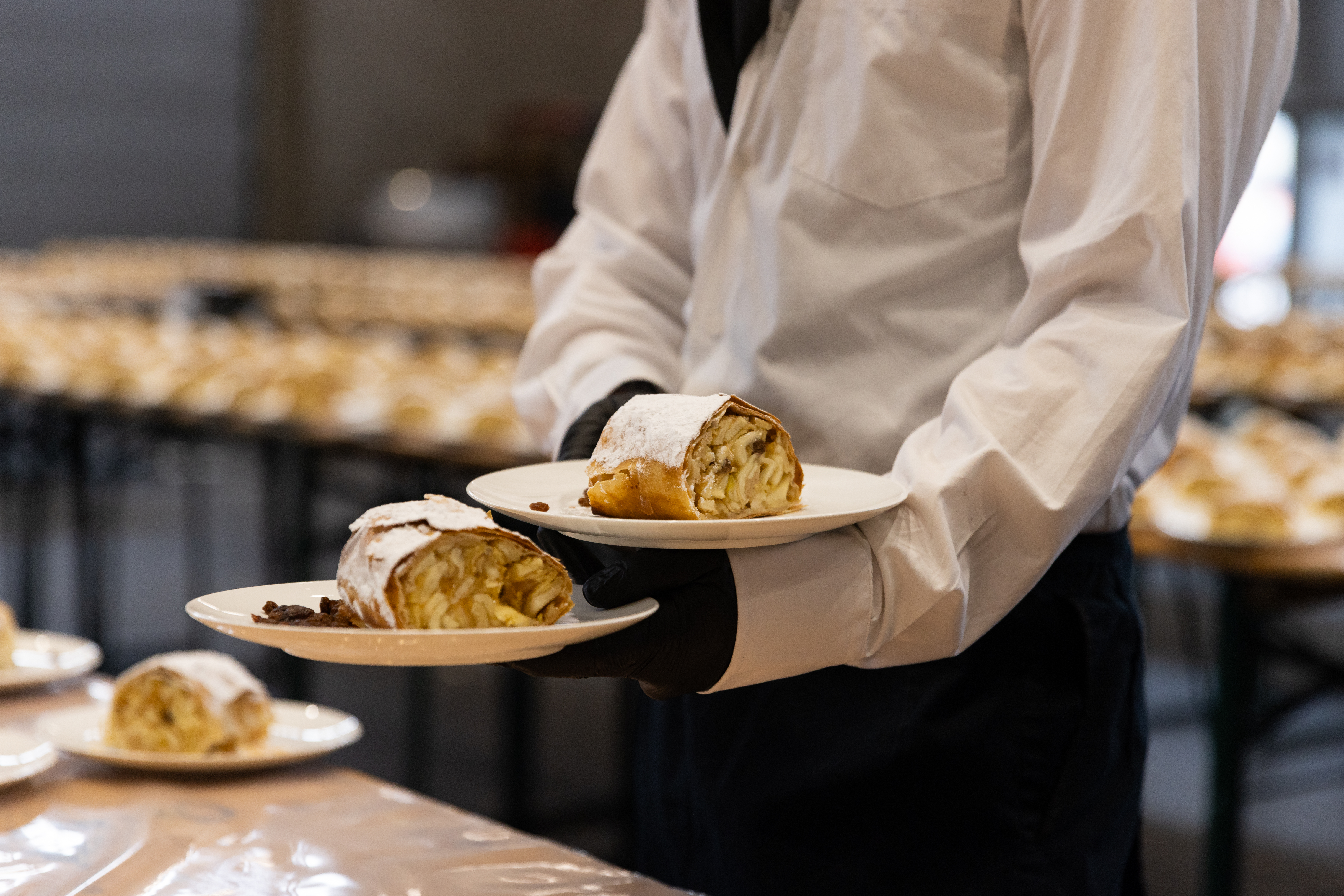 Catering staff serving traditional Viennese apple strudel during an event, showcasing hospitality and high-quality catering services at VIECON.