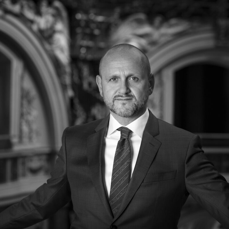 Portrait of Norbert Kettner, CEO of Vienna Tourist Board, photographed in a formal black-and-white setting.