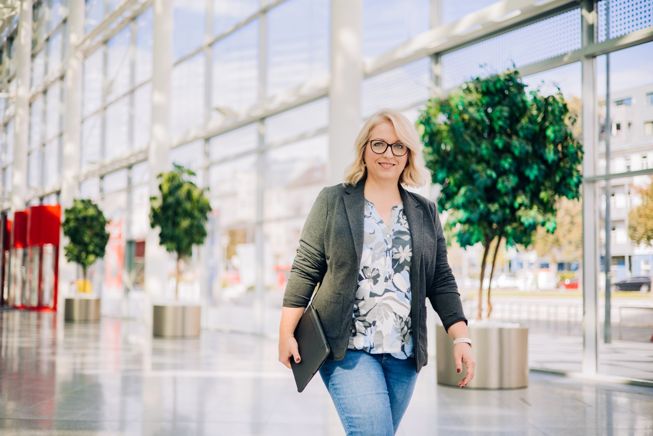 Susanne Zehntner, Head of Sustainability spaziert durch das Foyer der VIECON Messe Wien und blick in die Kamera